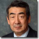 Older man wearing suit and tie, neutral expression