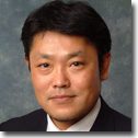 Man in dark suit smiling slightly