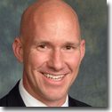 A bald man in a suit and tie.